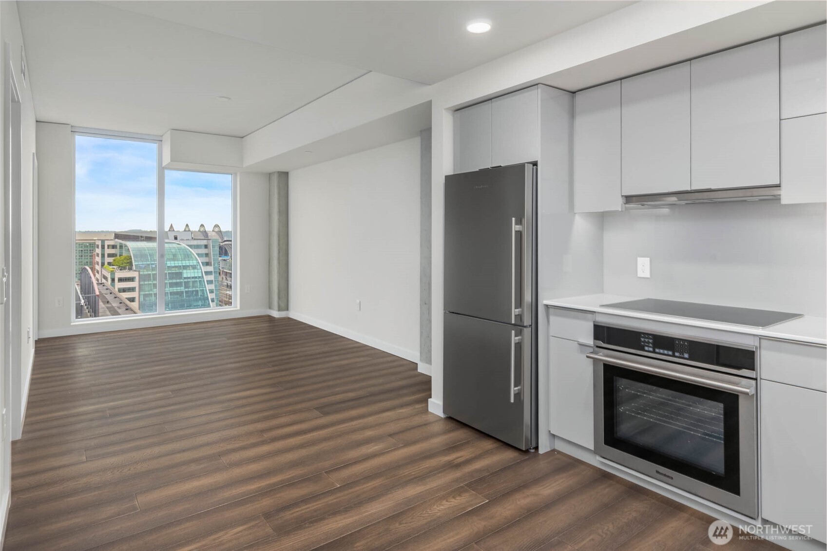 450 South Main Street, Unit 1405 Seattle, WA 98104 - Photo 7 of 38 a kitchen with wooden floors and stainless steel appliances