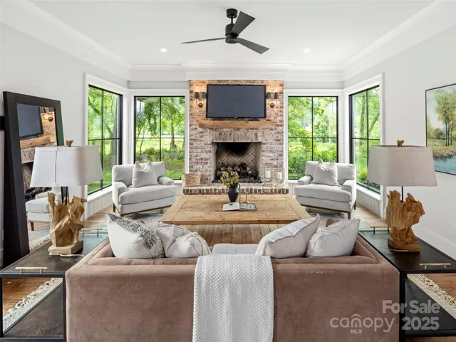 a living room with furniture a fireplace and a large window