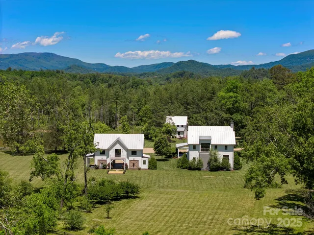 a kitchen with stainless steel appliances kitchen island granite countertop a sink a stove and a wooden floors