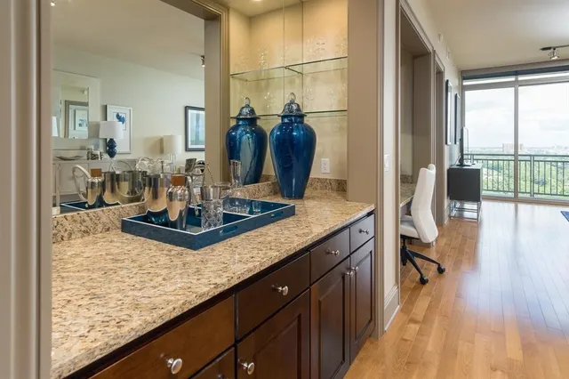 a kitchen with kitchen island granite countertop a table chairs and a wooden floor