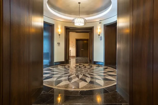 a view of a hallway with a dining room and chandelier