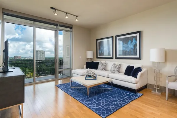 a living room with large couches rug and a large window