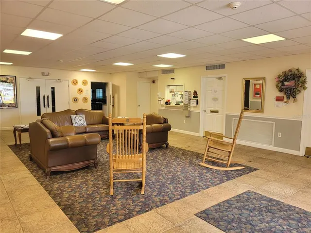 a living room with furniture pool table and chairs