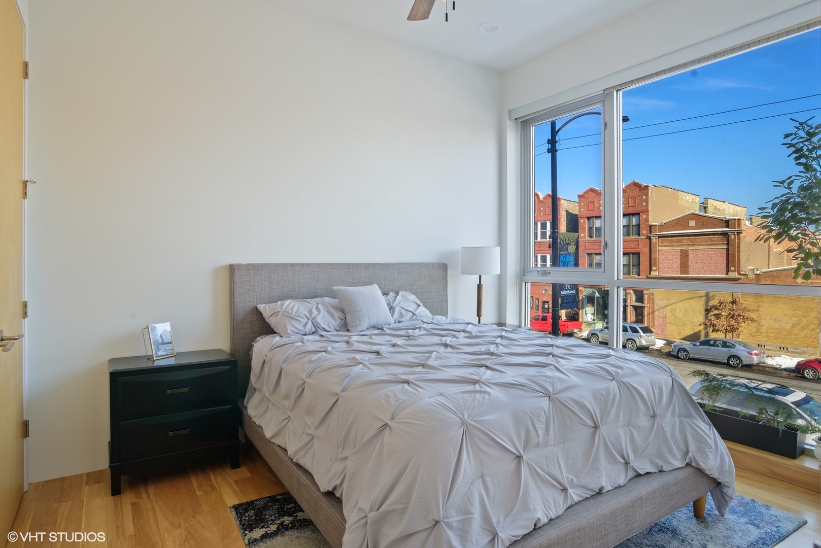 2408 West Rice Street, Unit 203 Chicago, IL 60622 - Photo 7 of 17 a bed sitting in a bedroom next to a window with a book shelf