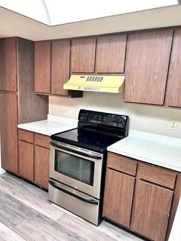 a kitchen with wooden cabinets and a stove top oven