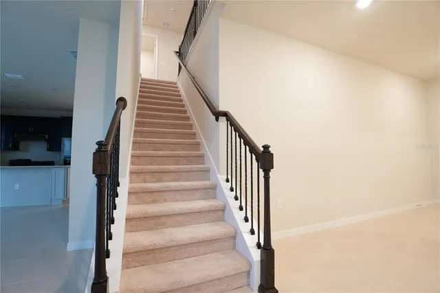 a view of staircase with white walls and railing