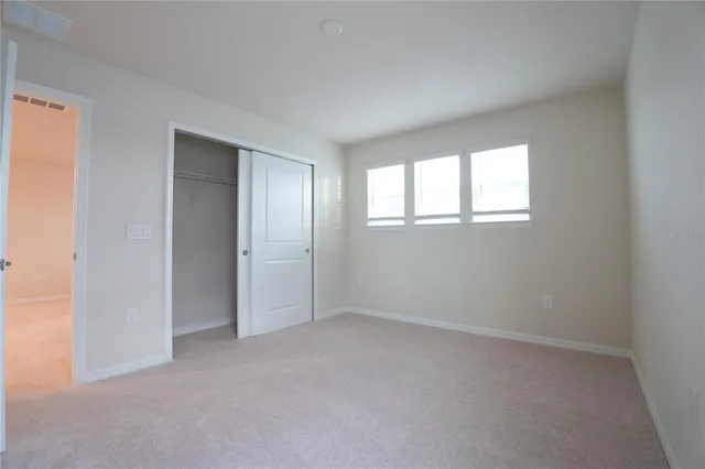 an empty room with windows and closet