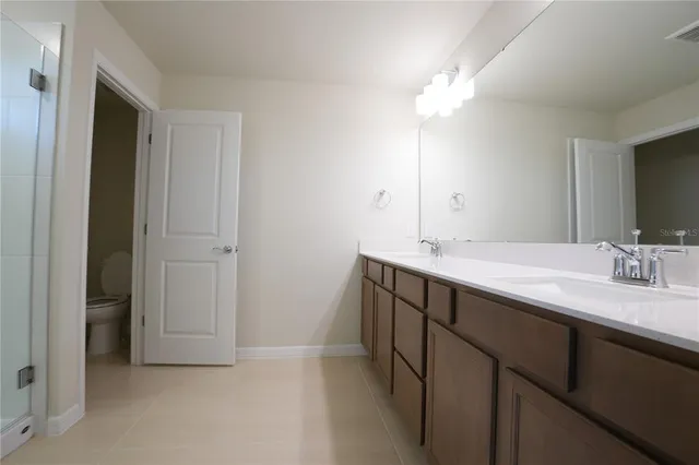 a bathroom with a double vanity sink and a mirror