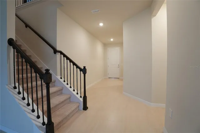 a view of a hallway with wooden floor and entryway