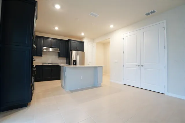 a view of kitchen with kitchen island and stainless steel appliances