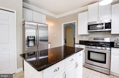 a kitchen with stainless steel appliances granite countertop a sink a stove and a refrigerator