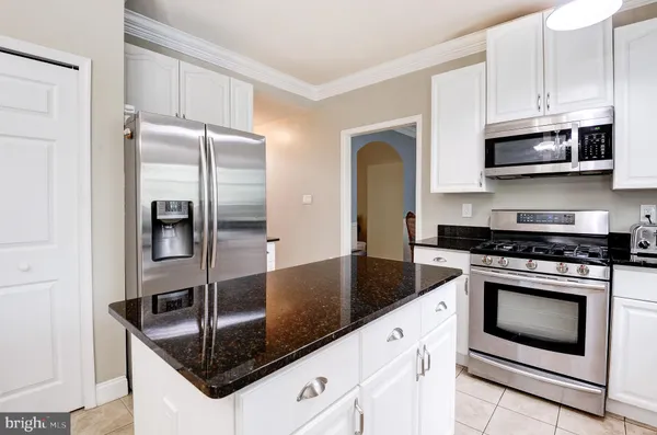 a kitchen with stainless steel appliances granite countertop a sink a stove and a refrigerator