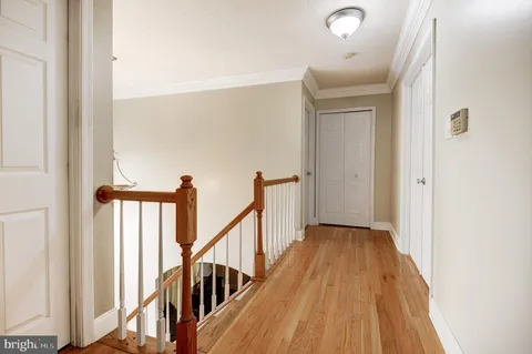 a view of a hallway with wooden floor and staircase