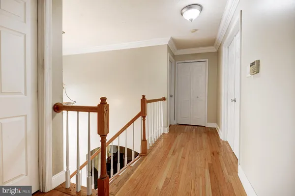 a view of a hallway with wooden floor and staircase