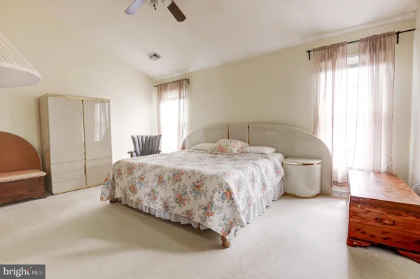 a spacious bedroom with a bed and a dresser