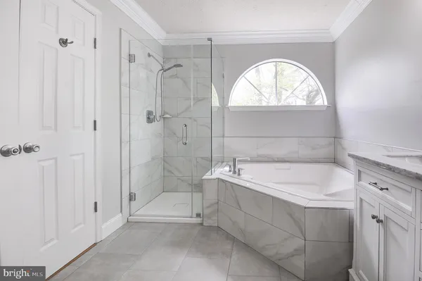 a spacious bathroom with a tub sink and mirror