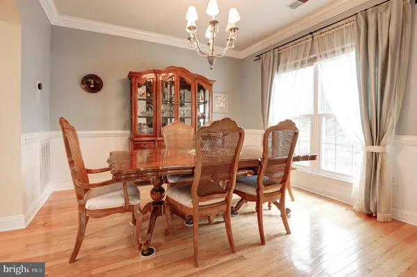 a dining room with furniture a chandelier and wooden floor