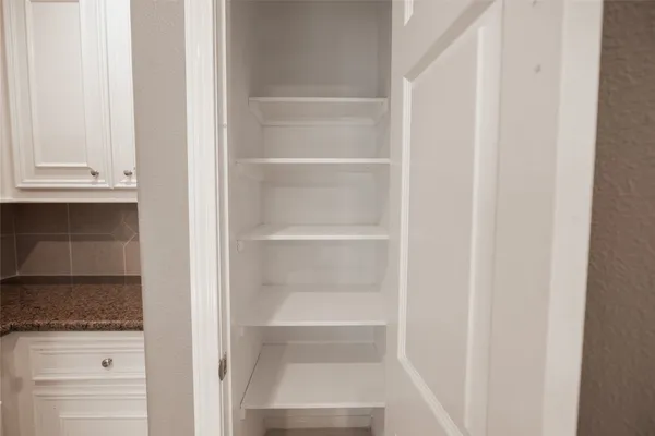 a view of walk in closet with empty racks