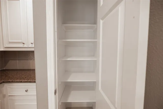 a view of walk in closet with empty racks