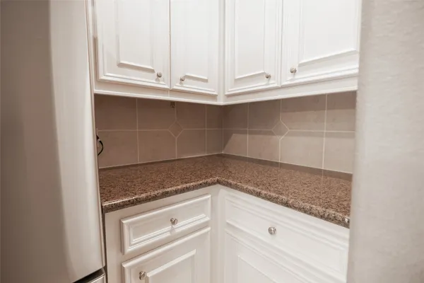 a view of white cabinets and a window