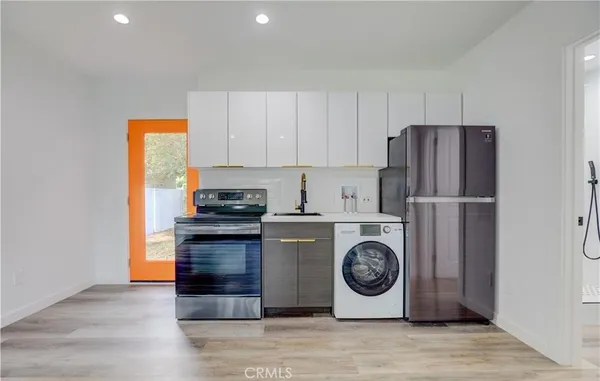 a kitchen with a refrigerator and a stove top oven