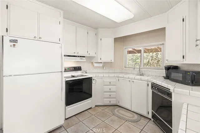 a kitchen with cabinets stainless steel appliances and sink
