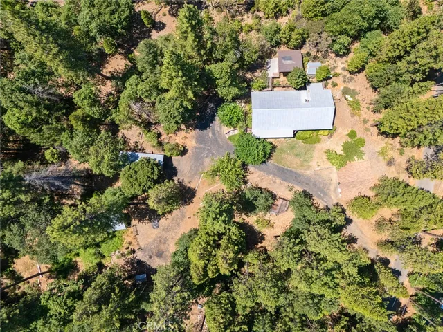 an aerial view of residential houses with outdoor space and trees all around