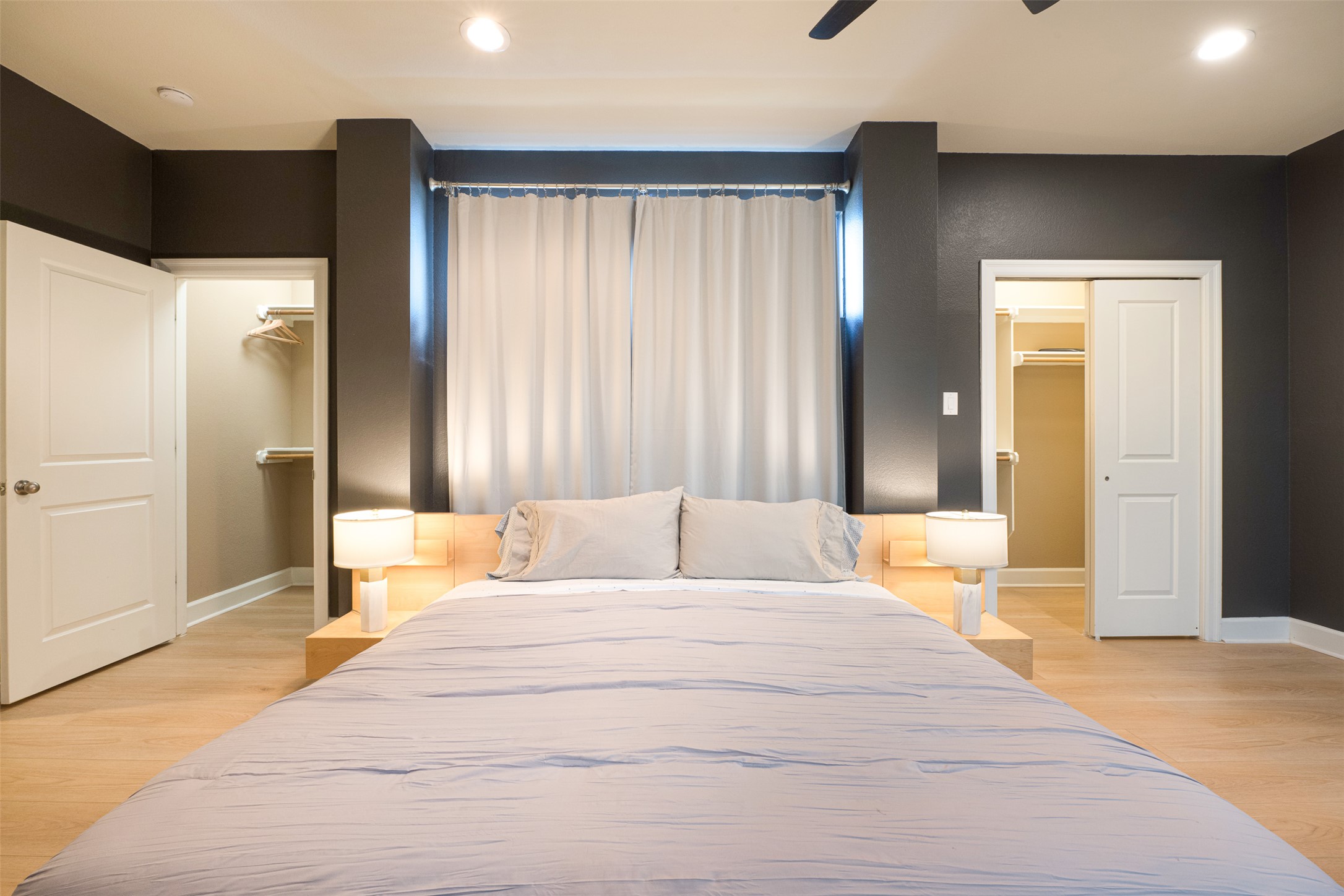 2302 East 9th Street Austin, TX 78702 - Photo 15 of 31 Recessed lighting and a ceiling fan illuminate this contemporary bedroom with bright wood flooring and ample closet space.
