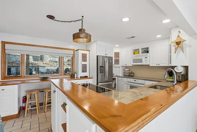 a bathroom with a granite countertop sink a mirror and shower