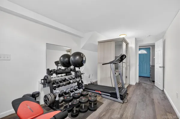 a room with gym equipment and wooden floor
