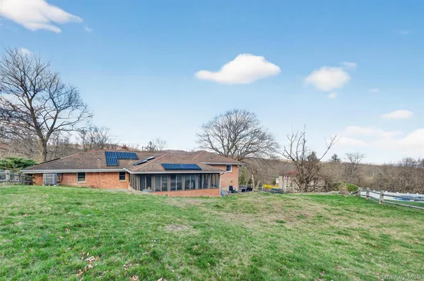 a view of a house with a big yard and large trees