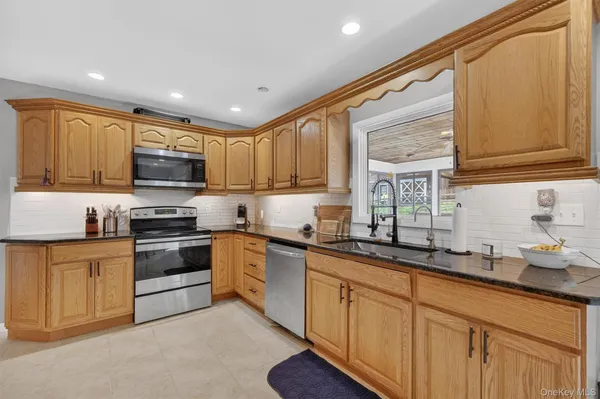 a kitchen with stainless steel appliances granite countertop a stove sink microwave and cabinets