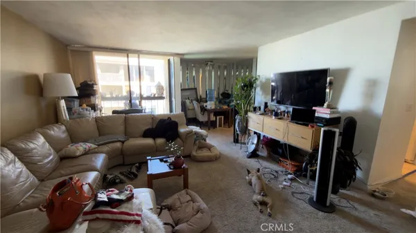a living room with furniture a flat screen tv and a window