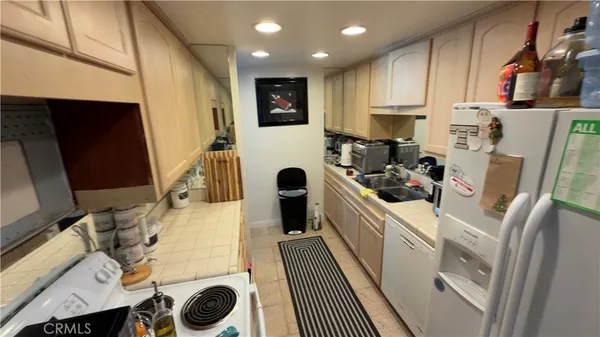 a kitchen with stainless steel appliances a refrigerator sink and wooden cabinets