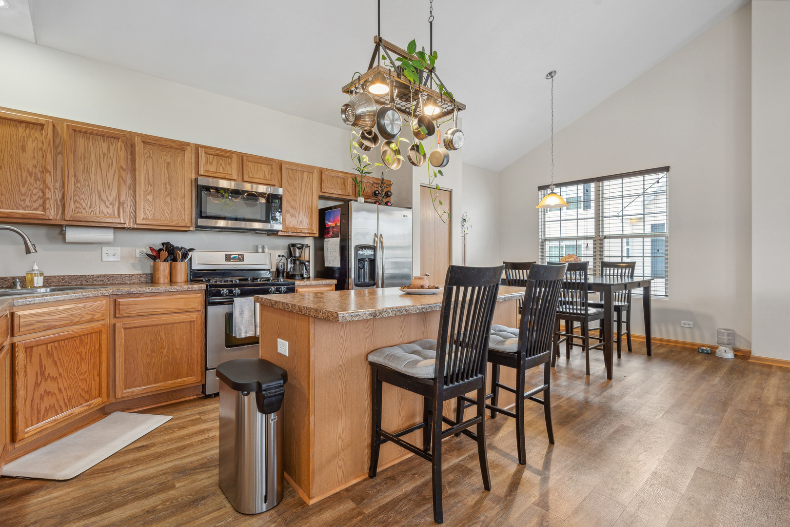 3752 Bailey Road, Unit 3752 Yorkville, IL 60560 - Photo 8 of 20 a kitchen with stainless steel appliances granite countertop a stove top oven a sink a dining table and chairs with wooden floor