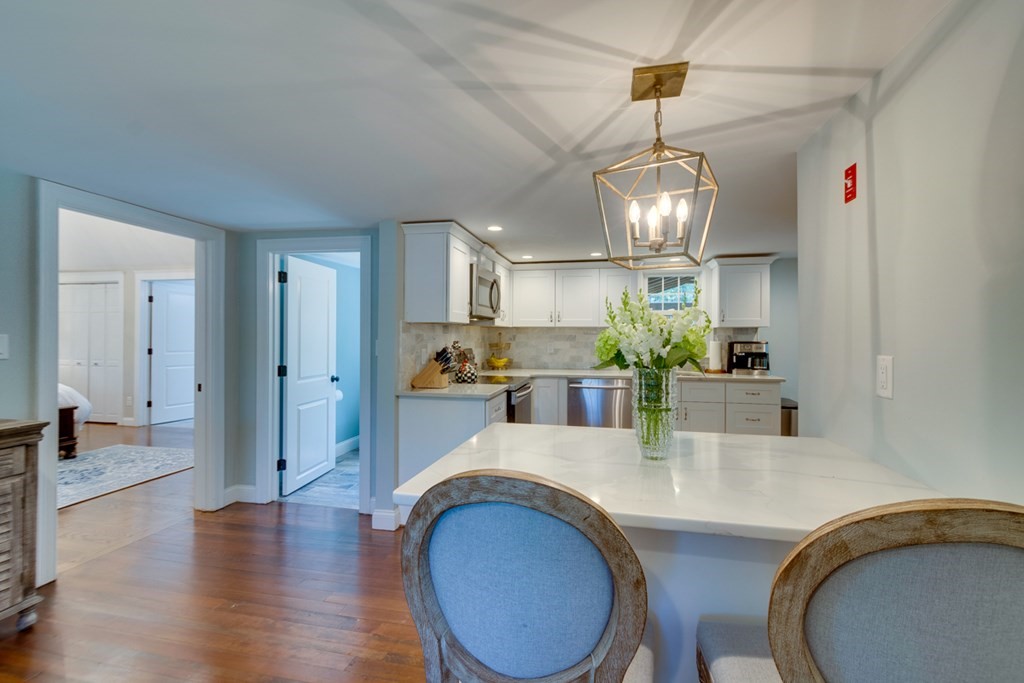 240 Summer Street Walpole, MA 02071 - Photo 12 of 34 a kitchen area with stainless steel appliances granite countertop a dining table chairs and granite counter tops