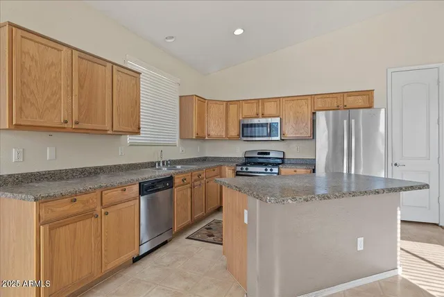 a kitchen with stainless steel appliances granite countertop a stove a sink and a refrigerator
