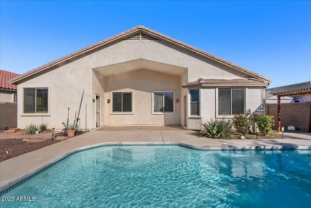 a view of a white house with a small yard and potted plants