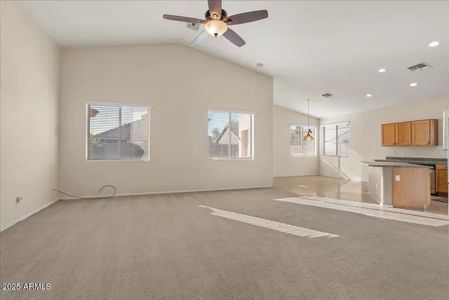 an empty room with windows and fan