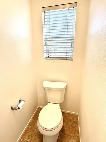 a bathroom with a toilet and a exposed radiator