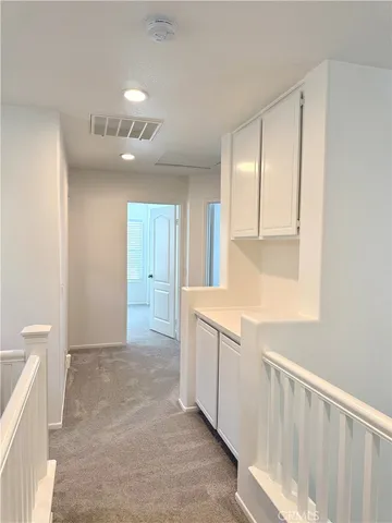 a view of a kitchen with white cabinets and wooden floor