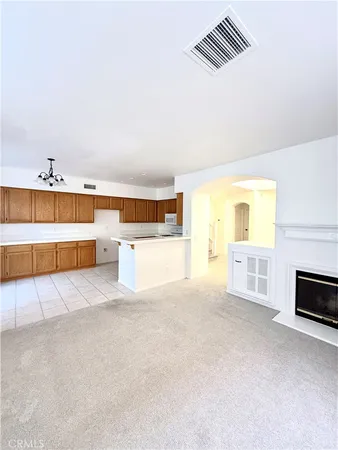 a view of an empty room with a fireplace and a window