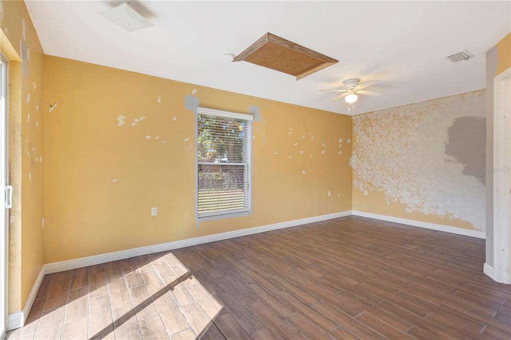 7737 Mitchell Ranch Road New Port Richey, FL 34655 - Photo 14 of 27 a view of an empty room with wooden floor and a window