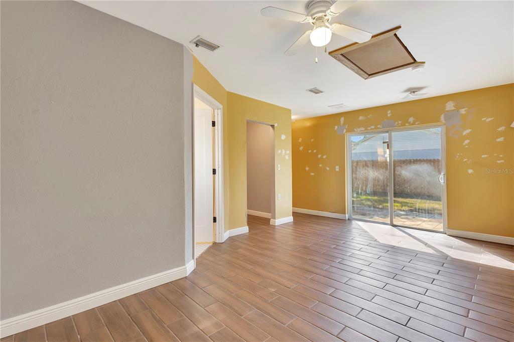 7737 Mitchell Ranch Road New Port Richey, FL 34655 - Photo 16 of 27 a view of an empty room with wooden floor and a bathroom
