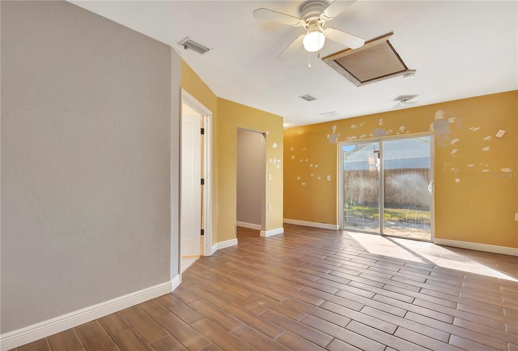 7737 Mitchell Ranch Road New Port Richey, FL 34655 - Photo 17 of 27 an empty room with wooden floor and windows