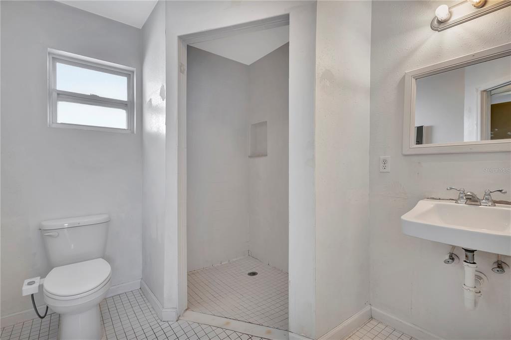 7737 Mitchell Ranch Road New Port Richey, FL 34655 - Photo 18 of 27 a bathroom with a toilet a sink and mirror