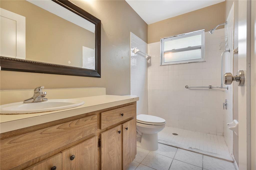 7737 Mitchell Ranch Road New Port Richey, FL 34655 - Photo 19 of 27 a bathroom with a sink a toilet a mirror and shower