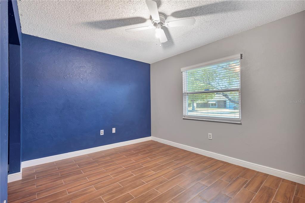 7737 Mitchell Ranch Road New Port Richey, FL 34655 - Photo 21 of 27 an empty room with wooden floor and windows