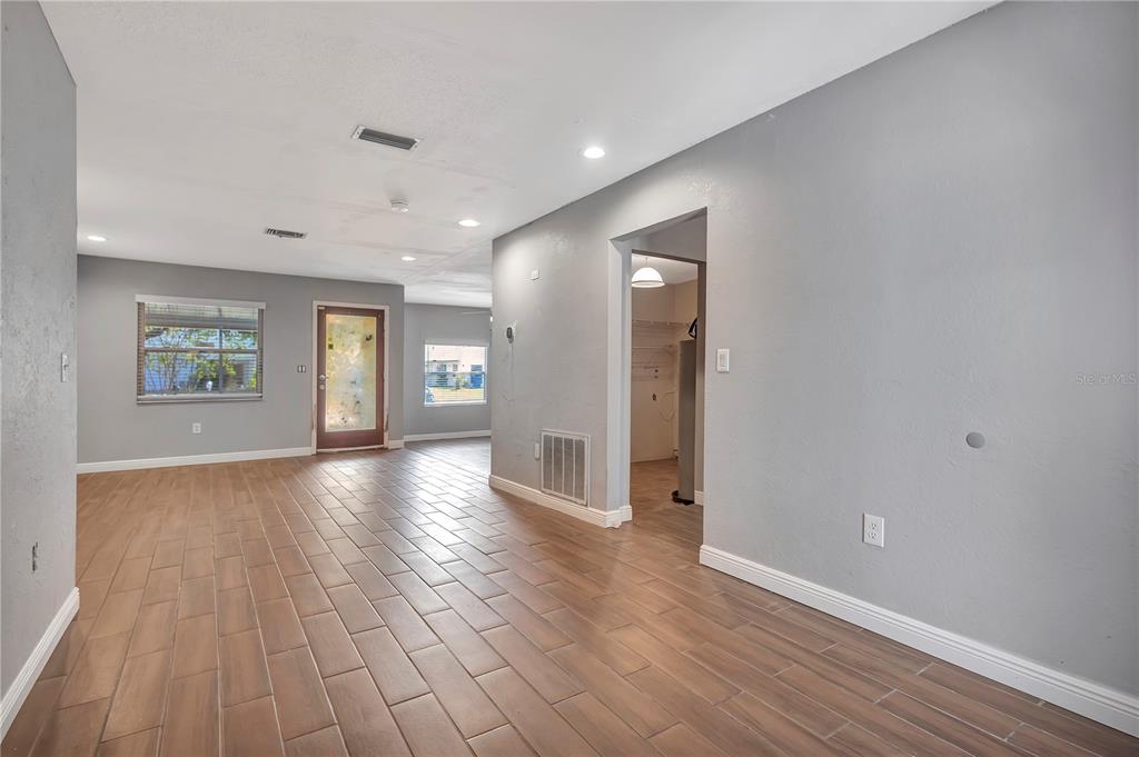7737 Mitchell Ranch Road New Port Richey, FL 34655 - Photo 5 of 27 an empty room with wooden floor and windows