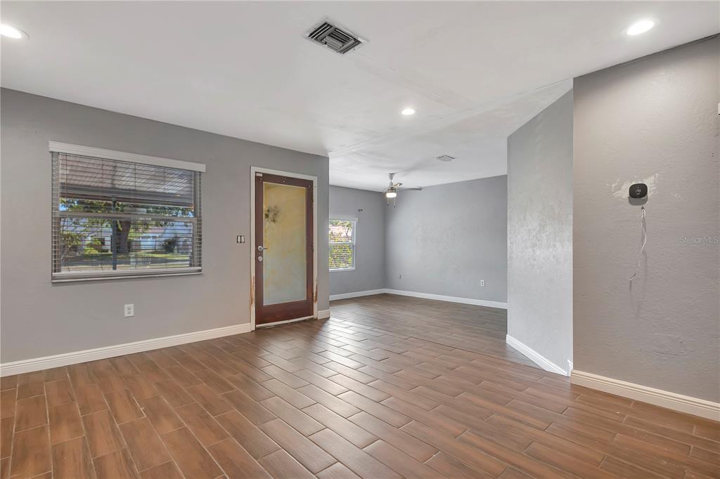 7737 Mitchell Ranch Road New Port Richey, FL 34655 - Photo 6 of 27 a view of an empty room with wooden floor and a window